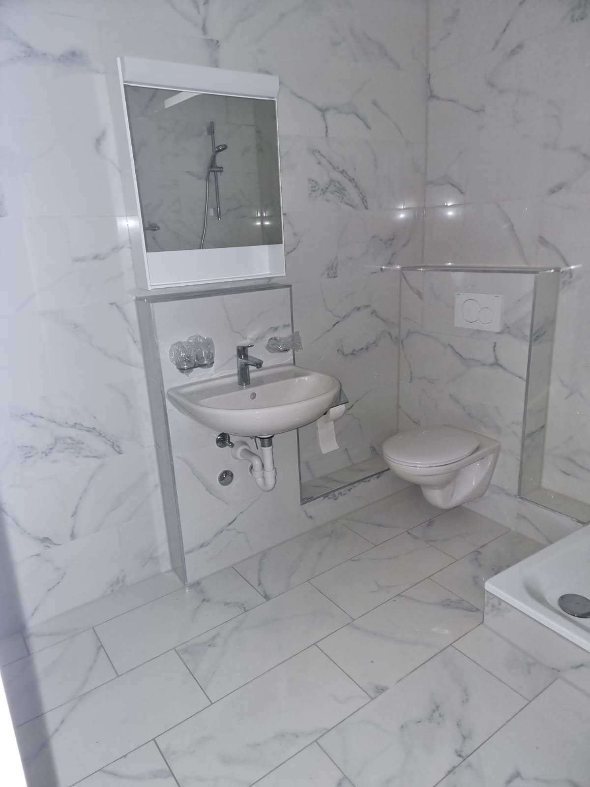Fertig saniertes Badezimmer mit Marmorfliesen und Waschbecken
